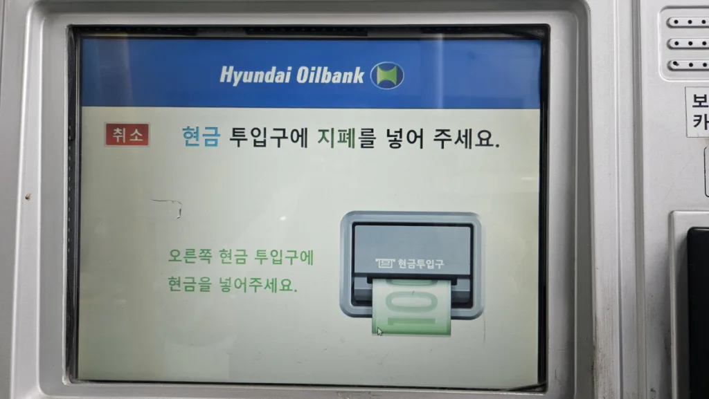 현금 투입구에 지폐 넣기