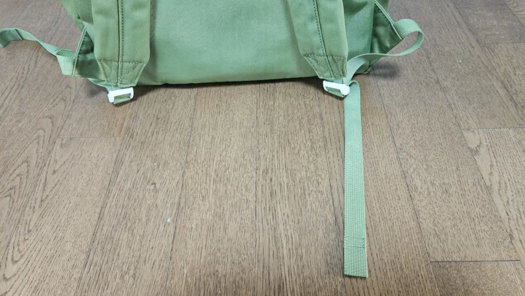 백팩 가방끈을 조절하고 남는 끈이 길게 나와 있는 모습