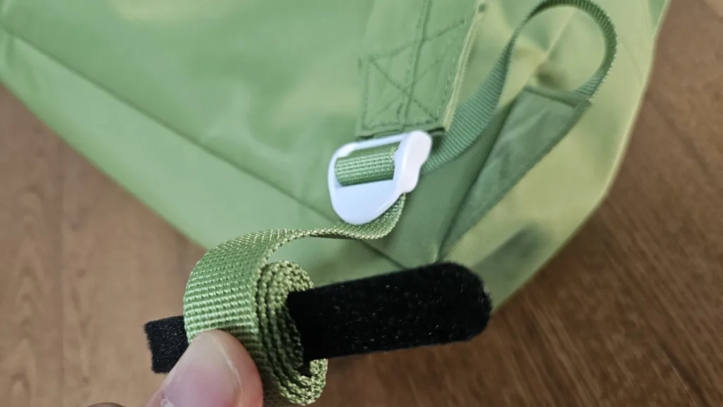 남는 가방끈에 벨크로를 대고 안쪽으로 말아주는 모습