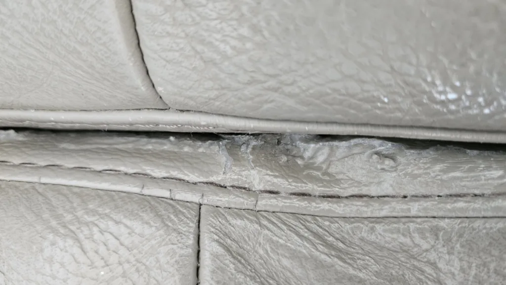 리클라이너 쇼파의 움직이는 부위가 찢어져 솜이 드러난 부분을 실리콘 접착제로 보수한 모습