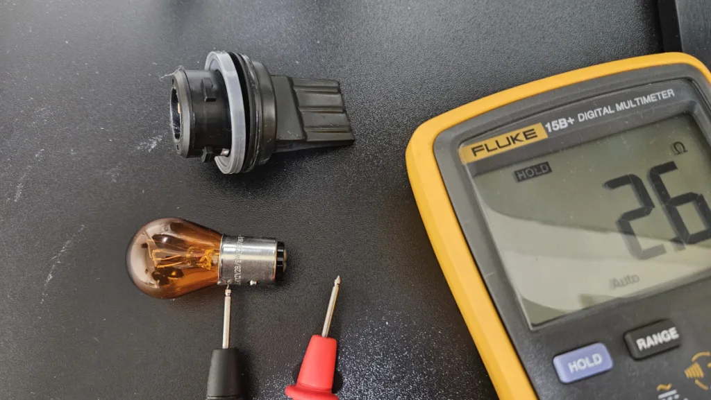멀티미터로 방향지시등 전구의 불량 여부를 확인하는 모습
